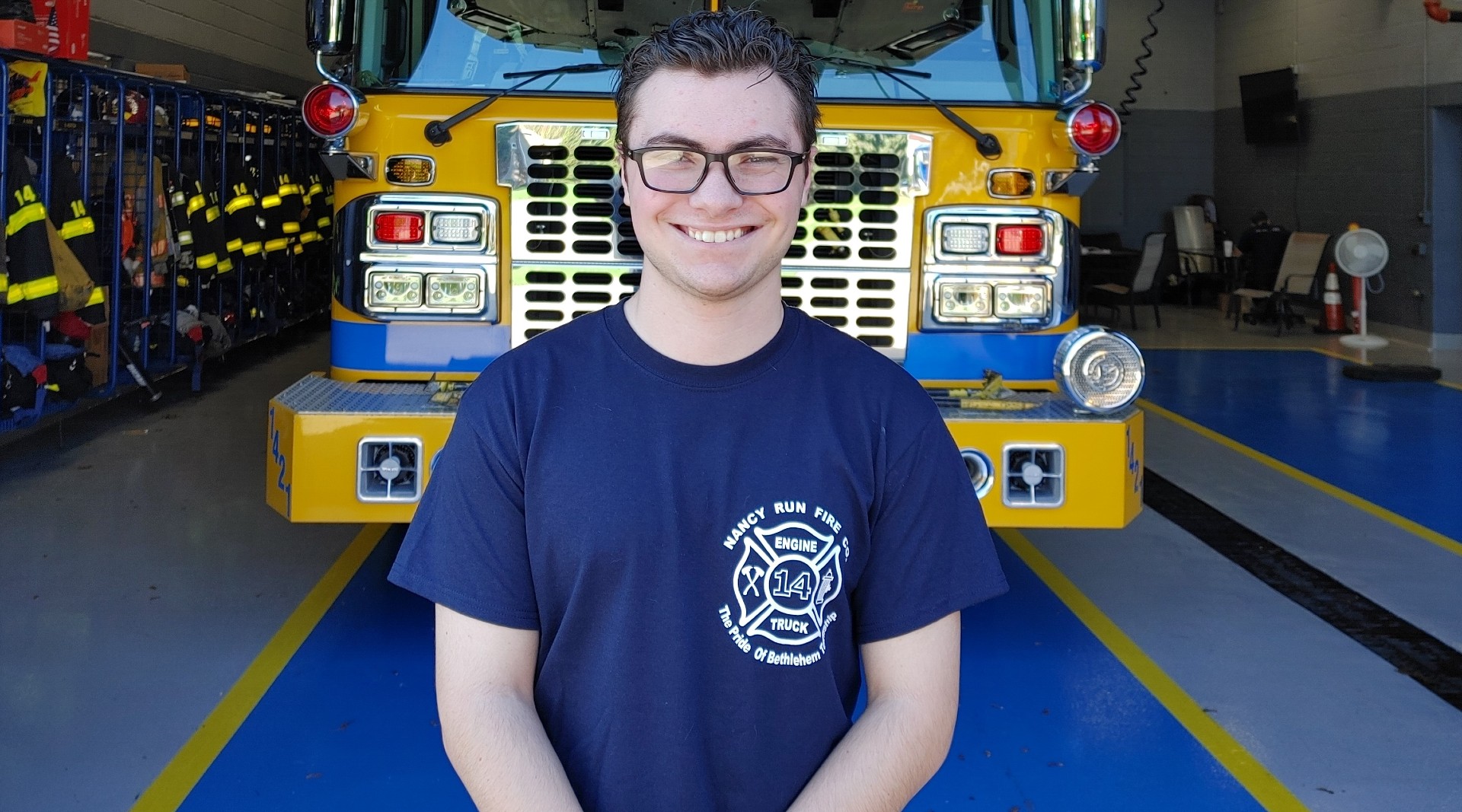 PA Virtual student stands in front of a firetruck at the station he volunteers at