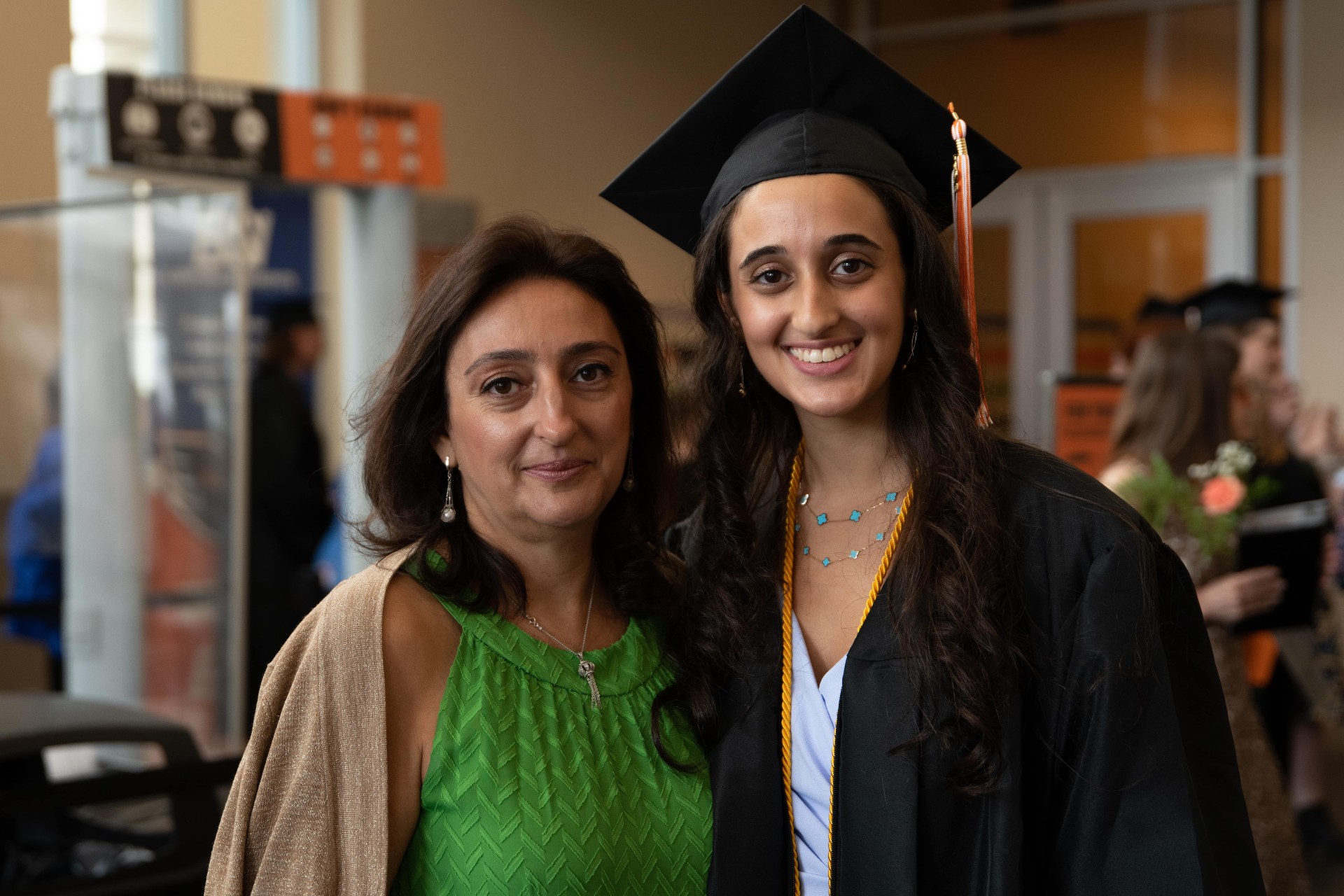 A mother in a green blouse and her graduate daughter wearing a cap pose for a photo at PA Virtual Graduation 2022.