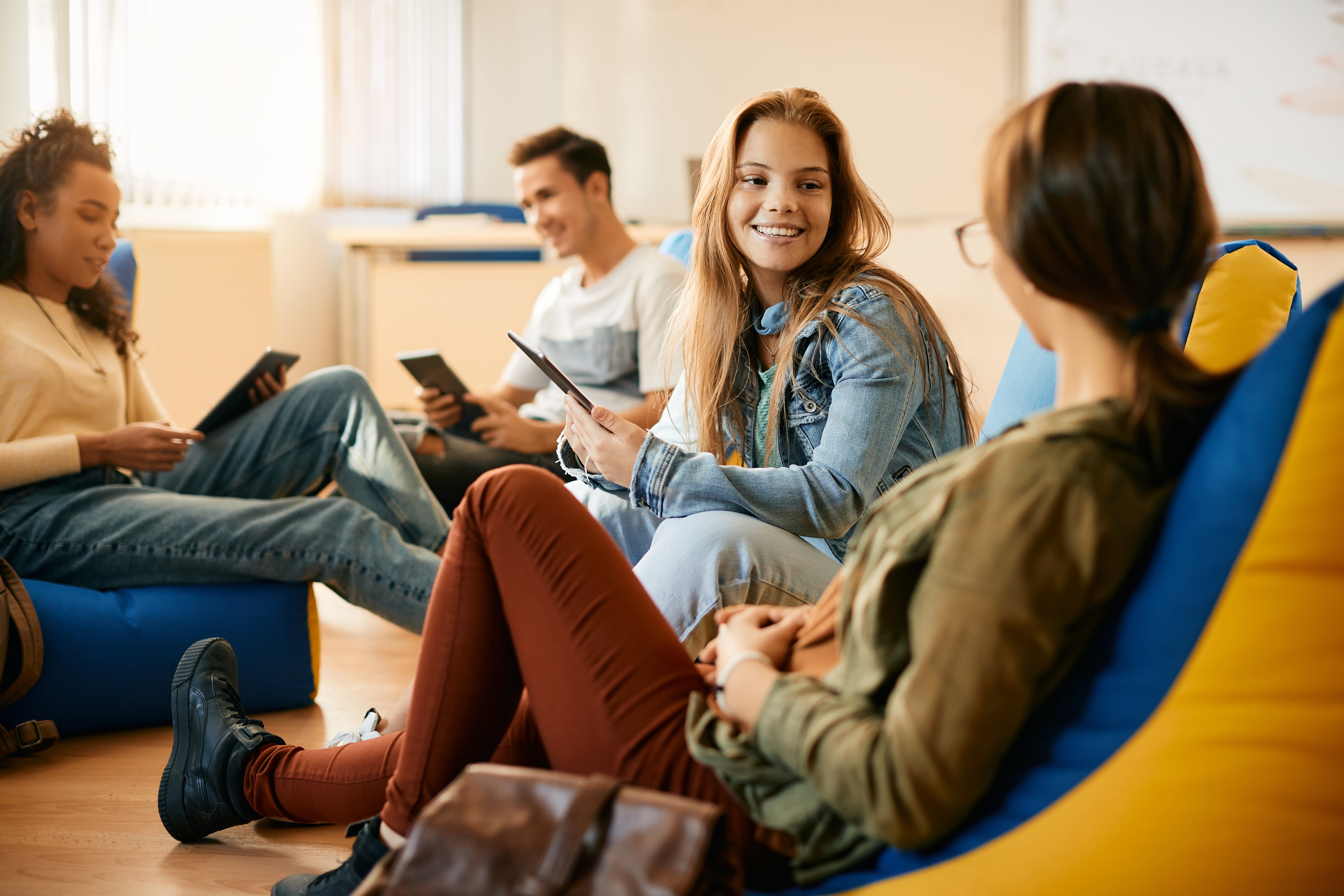 happy-female-student-using-touchpad-while-talking-2022-11-23-18-00-58-utc-min